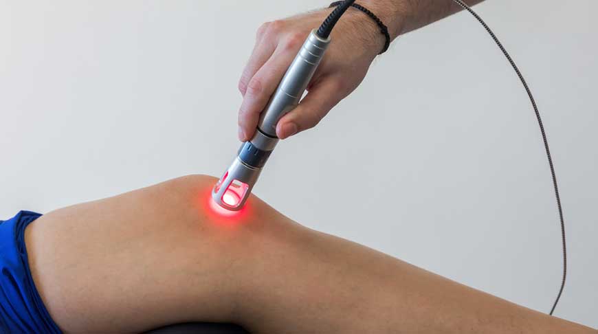 Patient doing hot laser therapy in  Concordfor his knee pain